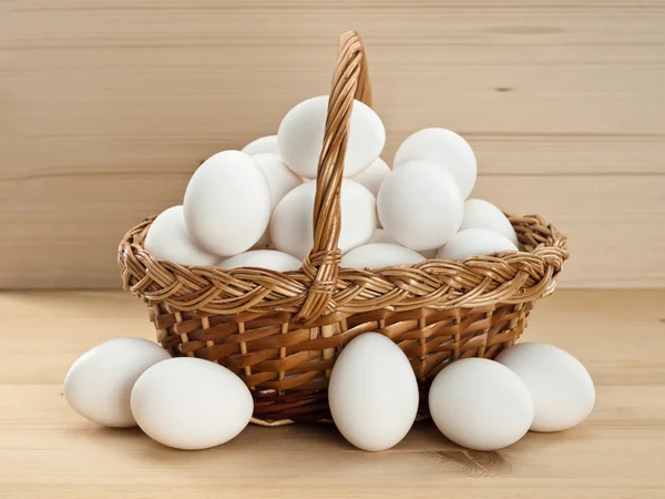 Cesta con huevos en una mesa de madera —  Fotos de Stock