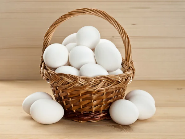 Cesta con huevos en una mesa de madera —  Fotos de Stock