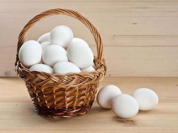 Cesta con huevos en una mesa de madera —  Fotos de Stock