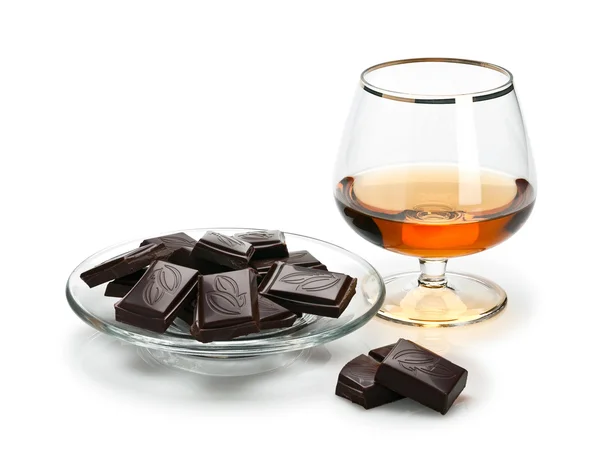 Chocolade en cognac in glaswerk die het is geïsoleerd op wit Rechtenvrije Stockafbeeldingen