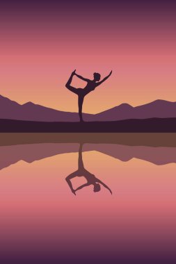 Kız gün batımında göl kenarında yoga yapıyor.