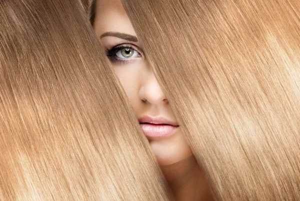 Girl look through shining shiny blonde hair — Stock Photo, Image