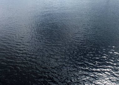 Karanlık su yüzeyi arkaplan duvar kağıdında güneş ışığı parlaması 