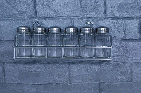 空のガラススパイス瓶上の灰色のレンガキッチンの壁 — ストック写真