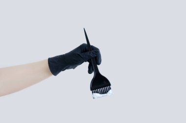 Saç boyası. Beyaz bir kadının elinde saç boyası olan siyah bir fırça..