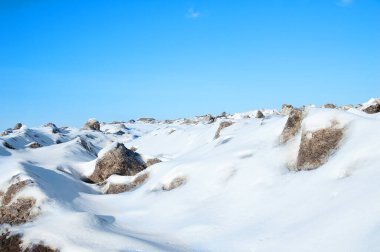 Öğleden sonra kış manzarası açık havada dağlarda mavi gökyüzüne karşı.