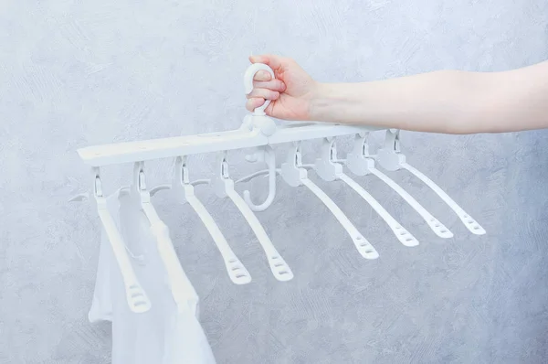 White Plastic Folding Clothes Hanger Eight Hangers Hands Caucasian Woman — Stock Photo, Image