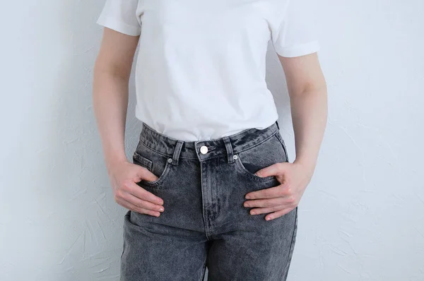 Vit Kvinna Grå Jeans Och Vit Shirt Bakgrunden Vit Vägg — Stockfoto