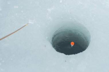Kışın balık. Kış balıkçılığı gezisinde şamandıralı bir delik..