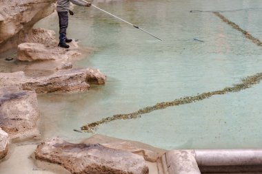 Roma, İtalya. 2020 kışı. Trevi Çeşmesini bozuk paralarla temizliyorum. Özel bir elektrikli süpürgeyle bozuk para pompalamak