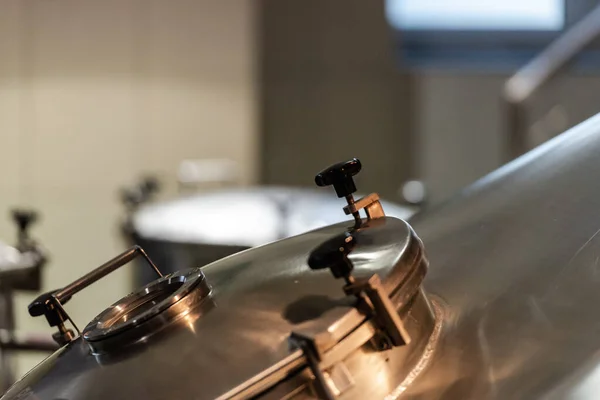 Hatch to the beer tank. Beer brewing tank at the factory.