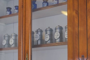 Eski bir eczanede konserveli raflar. Cam raflı dolaplar. İlaçlı bankalar.