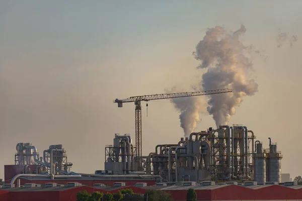 Factory in the east of Italy. Factory at sunset with pipes and crane.