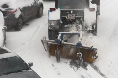 Moskova. - Rusya. Kış 2019. Küçük bir traktör evin yakınındaki yoldan karları temizliyor..