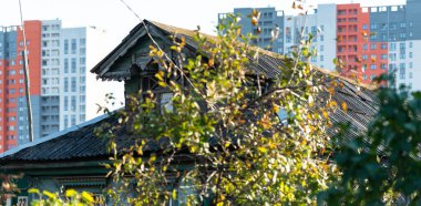 Çok katlı binaların arkasındaki eski ahşap ev.