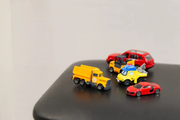 Bunte Spielzeugautos Auf Einem Schwarzen Stuhl Kinderautos Warten Auf Ihr — Stockfoto