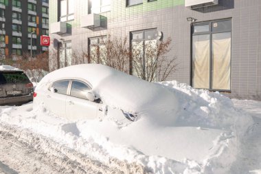 Moskova. - Rusya. Şubat ayında kar yağışı. Kar yığınındaki araba. Şiddetli bir kar yağışından sonra araba her taraftan karla kaplıydı. Bırakmak için kürekle çalışmak zorundasın.