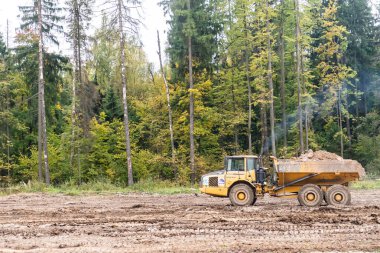 Moskova Oblastı. - Rusya. 2019 sonbaharında. Yoldaki off-road kamyonu çalışıyor. Büyük bir araba arkasında kil taşır.