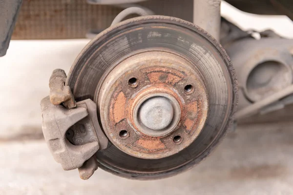Heavily worn brake disc. Car brake disc after removing the wheel. A rusty disk that needs to be replaced.