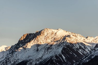 Güneş ışığındaki Elbrus bölgesi. Batan güneşin ışığında çok büyük bir dağ..