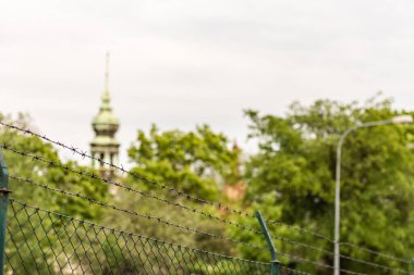 Dikenli tellerin arkasındaki Brno tapınaklarından birinin kulesi. Avrupa dikenli tellerin arkasında.
