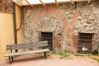 Eski ortaçağ kasabasının avlusunda. Barga 'da eski bir dükkânı olan bir avlu. Pergola 'nın altındaki eski duvarlardan birinin yanında bir dinlenme yeri..