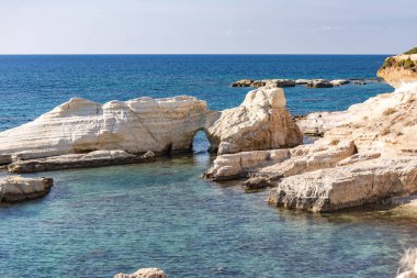 Kıbrıs koyları ve koyları. Geçitten geçen kayalar. Mağaraları ve taşları olan lagünün mavi suları. Güzel bir adanın her zamanki kıyısı..