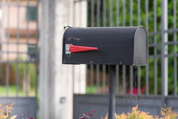巴尔加街上的信箱意大利山区一所房子前面的信箱 带有红旗的老式黑色信箱 — 图库照片