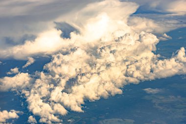 Bulutlar 10 kilometre yükseklikten geliyor. Uçak penceresinden gelen bulutlar denizi. Mavi gökyüzü ve beyaz bulutlar. Beyaz Sessizliğin Cennet Dünyası