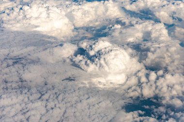 Bulutlar 10 kilometre yükseklikten geliyor. Uçak penceresinden gelen bulutlar denizi. Mavi gökyüzü ve beyaz bulutlar. Beyaz Sessizliğin Cennet Dünyası