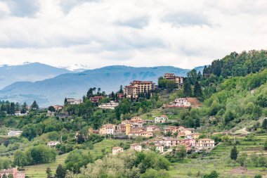 Dağlardaki şehrin tepesindeki gözlem güvertesinden bak. Barga kasabası yakınlarındaki Toskana dağlarının yamaçlarında evleri olan bahçeler ve sebze bahçeleri..