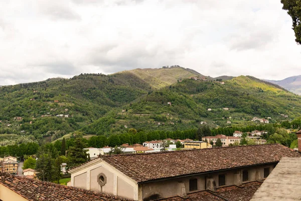 Eski kiremitli çatı. İtalya 'nın dağlarındaki Toskana' nın ortaçağ şehri Barga 'nın güzel çatıları. Şehrin dışındaki güzel dağlar.