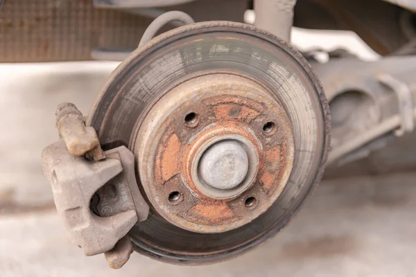 Old car brake disc. The brakes on the car require regular maintenance. Very close-up of the brake disc and pads when replacing the wheel.