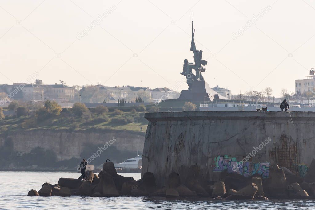 Monument to the defenders of Sevastopol from the sea. Entrance to the bay of Sevastopol with breakwaters.