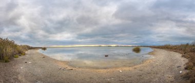 Bulgaristan 'ın Burgaz bölgesindeki Pomorie kasabası yakınlarındaki Pomorie tuz gölünün panoramik manzarası. Panorama