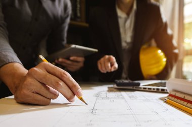 Çalışma ve tablet hakkında konuşan iki meslektaş, ofisteki inşaat alanında mimari projeyle ilgili bilgisayarı açtılar.