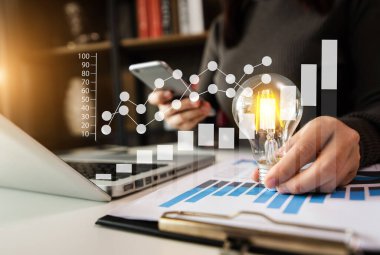 Akıllı telefon, tablet ve ampul kullanan iş kadını, yenilikçi ve yaratıcı fikirlerle