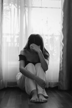 Kadın depresyonda. Pencere kenarında duruyor ve endişe duyuyor. Boşluğu kopyala.. 