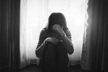 Kadın depresyonda. Pencere kenarında duruyor ve endişe duyuyor. Boşluğu kopyala.. 