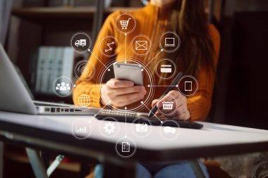 Beyaz masa üzerinde cep telefonu ve dizüstü bilgisayar kullanan iş kadını. İş zekası kavramına sahip büyük veri analizleri. VR grafiği ve simgeyle grafikle