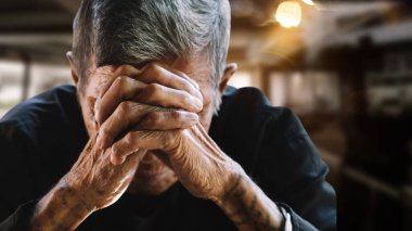 Üst düzey bir adam elleriyle yüzünü kapatıyor. Depresyon ve endişe Boşluğu kopyala