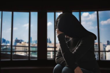 Kadın depresyonda. Pencere kenarında duruyor ve endişe duyuyor. Boşluğu kopyala..