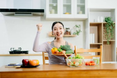 Genç bayan taze meyve, sebze ve besleyici malzemelerle sağlıklı tarifler hazırlıyor. Temiz ve sağlıklı bir yaşam tarzı için mükemmel.