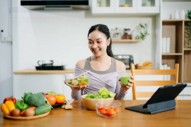Genç bayan taze meyve, sebze ve besleyici malzemelerle sağlıklı tarifler hazırlıyor. Temiz ve sağlıklı bir yaşam tarzı için mükemmel.