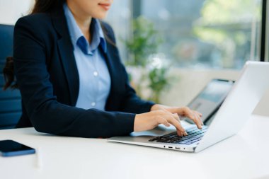 İş kadını el bilgisayarı cep telefonu ve modern bilgisayar ile sanal ekranda sabah ışığında dijital pazarlama medyasında çalışıyor