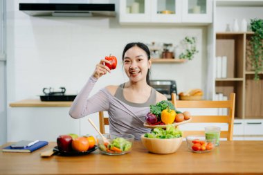 Mutfakta genç bir kadın ve evde sağlıklı yemek tarifi ya da günlük diyet yazıyor. Aktif sağlıklı yaşam tarzı, temiz yeme konsepti