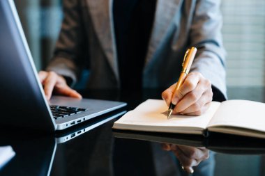 Yeni modern bilgisayarla çalışan iş kadını el yazısı ve not defteri strateji diyagramı sabah ışığı konsepti.