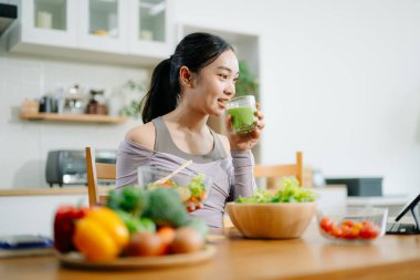 Genç bayan taze meyve, sebze ve besleyici malzemelerle sağlıklı tarifler hazırlıyor. Temiz ve sağlıklı bir yaşam tarzı için mükemmel.