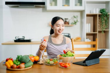Genç bayan taze meyve, sebze ve besleyici malzemelerle sağlıklı tarifler hazırlıyor. Temiz ve sağlıklı bir yaşam tarzı için mükemmel.