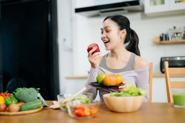Mutfakta genç bir kadın ve evde sağlıklı yemek tarifi ya da günlük diyet yazıyor. Aktif sağlıklı yaşam tarzı, temiz yeme konsepti